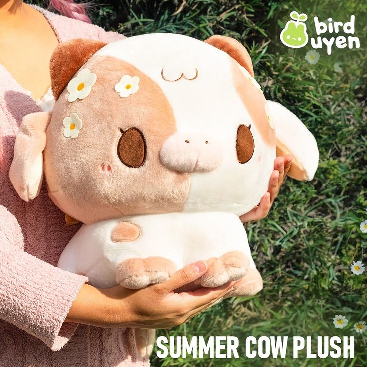 a woman holding a stuffed animal in her hands with the caption summer cow plush