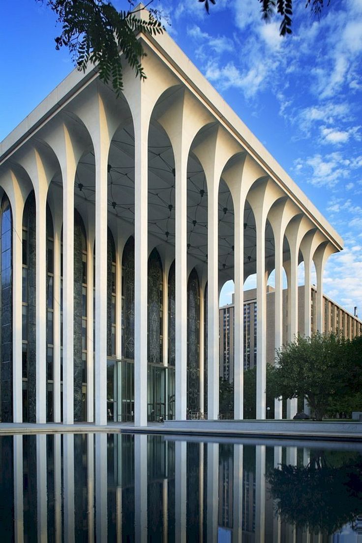 an architectural building with columns reflecting in the water