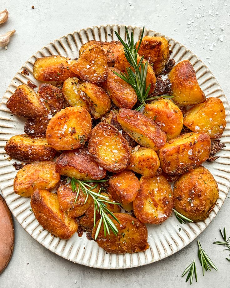 a white plate topped with fried potatoes covered in seasoning