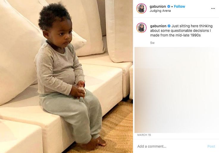 a baby sitting on top of a white couch