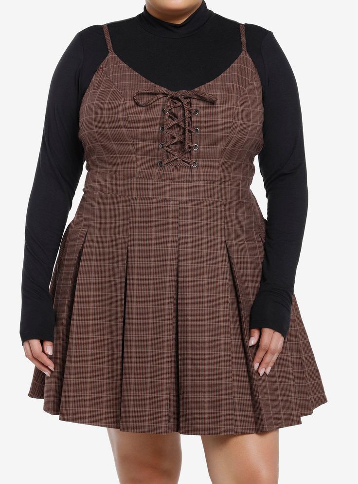 Class is in session! Get the dark academia look with this twofer dress! Featuring a brown plaid dress with lace-up detailing at the chest and a pleated skirt. Comes with a black mock neck long-sleeve underneath  adjustable straps  side zipper and pockets.Please note: Dress is fitted with no stretch; size up for a looser fit.65% polyester; 35% rayonWash cold; dry lowLength: 40''ImportedModel is 5'10''Model wears size 1 Plus Size Indie Outfits, Fashion For Chubby Ladies, Plus Size Pastel Goth, Brown Plaid Dress, Academia Look, Dark Academia Look, Twofer Dress, Dark Academia Clothes, Casual Dresses Plus Size