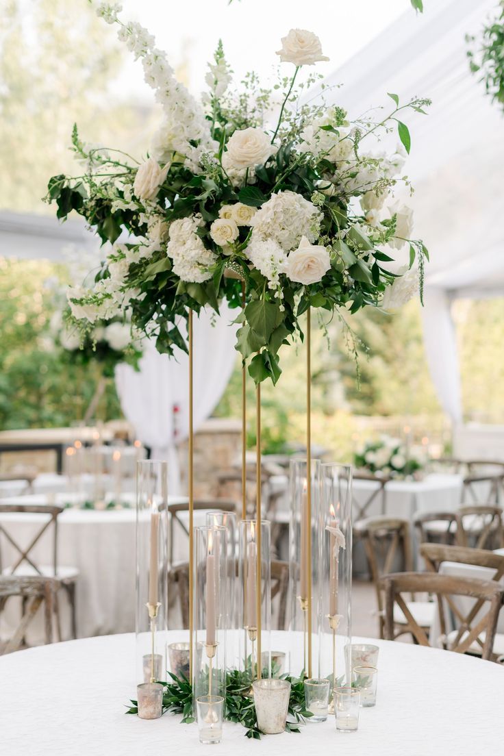 the centerpieces are filled with white flowers and greenery