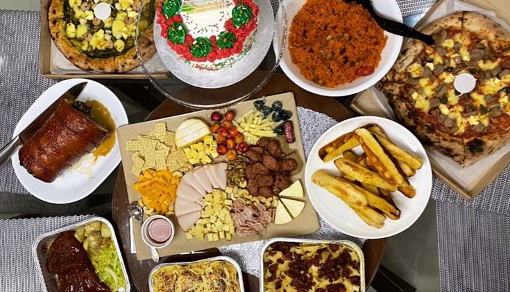 a table topped with lots of different types of pizzas and other foods on plates