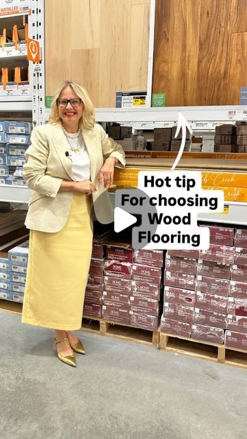 a woman standing next to a sign that says hot tip for choosing wood flooring