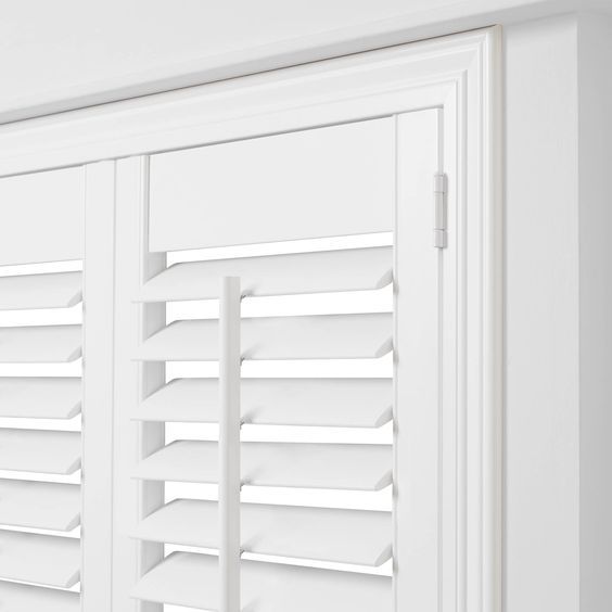 the shutters are closed to let in light on the room's white walls