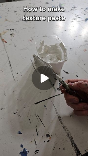 a person is painting with white paint on a table and the text reads how to make texture paste