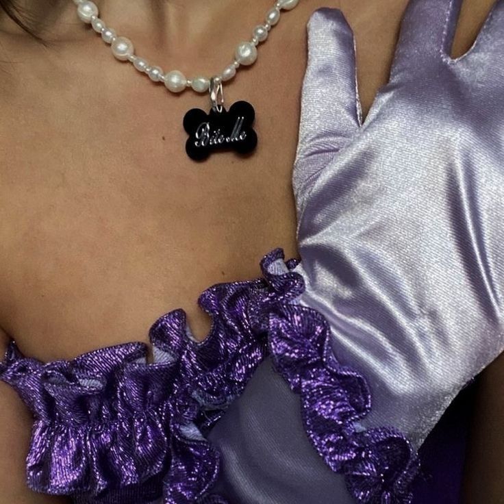 a close up of a woman wearing a purple dress with a black heart on it