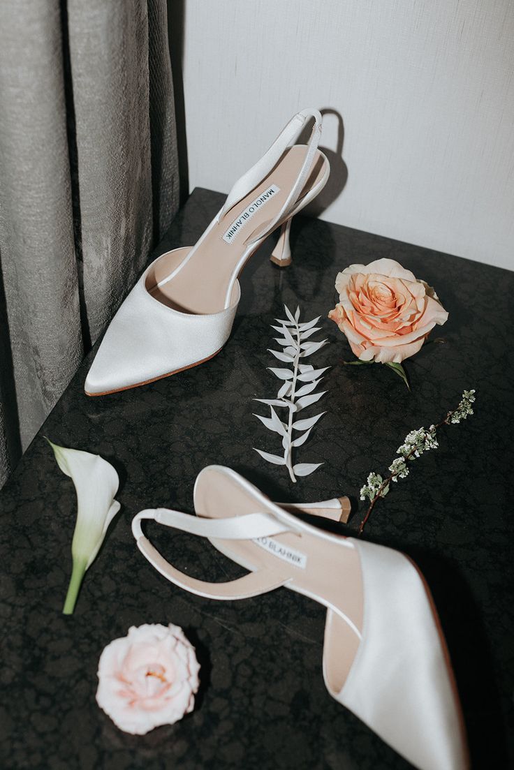 the bride's shoes and boutonnieres are sitting on a black table