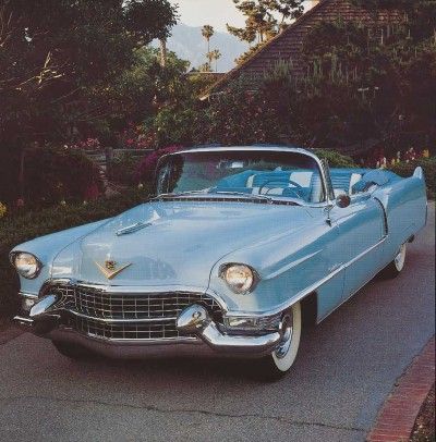 an old blue car is parked on the street