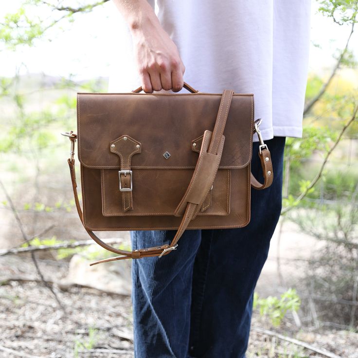 Introducing our newest addition to the shop, the Leather Messenger Bag - a timeless creation crafted from premium leather, exuding sophistication and mystery. With a sleek design, hand-stitched details, and curated hardware, it effortlessly elevates your style. Stay organized with its roomy interior and multiple pockets. Turn heads as you make a statement with this work of art by your side. Fits up to 13" laptops Authentic American Full Grain Leather Silver hardware, including buckles, rivets, a Everyday Briefcase With Top Handle And Smooth Grain, Top Handle Satchel With Vegetable Tanned Leather, Everyday Leather Rectangular Laptop Bag, Leather Bags With Smooth Grain For Office, Daily Use Leather Flap Bag With Soft Leather, Vegetable Tanned Leather Satchel With Top Handle, Soft Leather Flap Bag For Daily Use, Leather Top Handle Backpack For Everyday Use, Everyday Leather Satchel With Top Handle