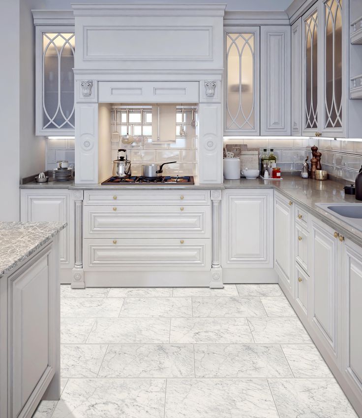 a kitchen with white cabinets and marble counter tops