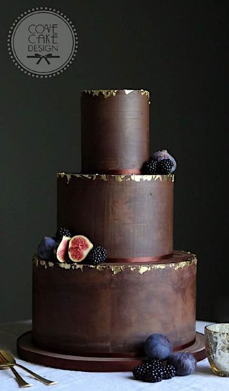 a three tiered chocolate cake with figs on top