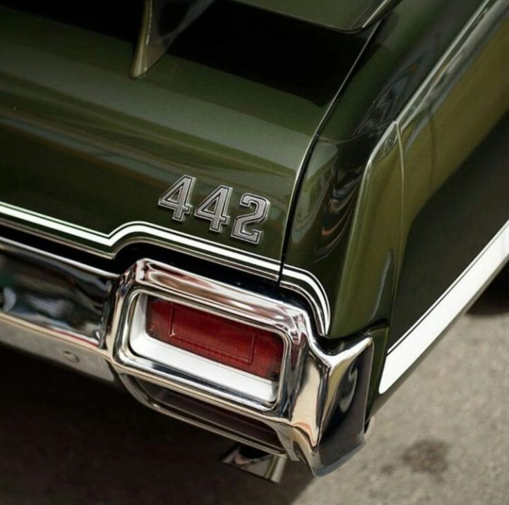 an old green car with the number 544 on it's license plate is parked