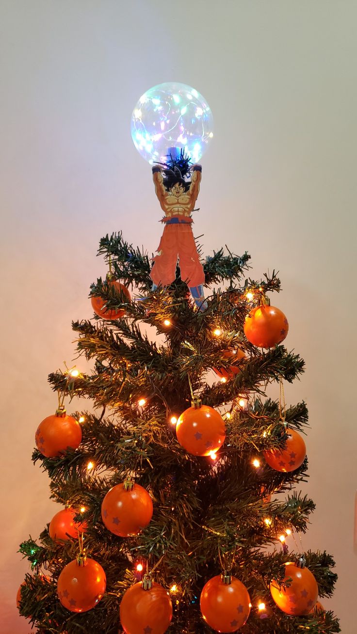 a christmas tree with oranges on it and an inflatable ball hanging from the top