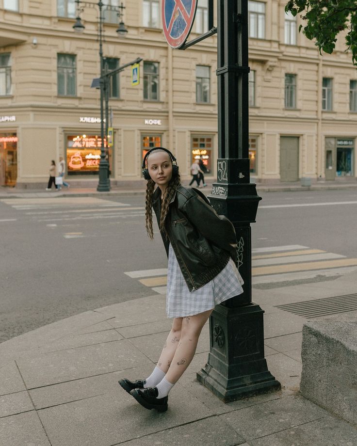 a woman standing next to a street sign