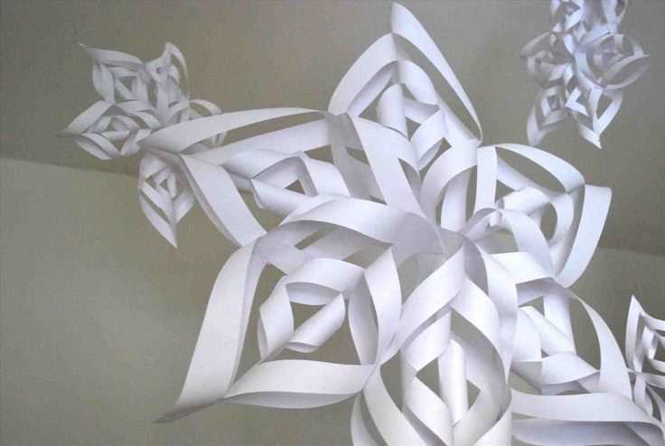 an intricate snowflake made out of white paper