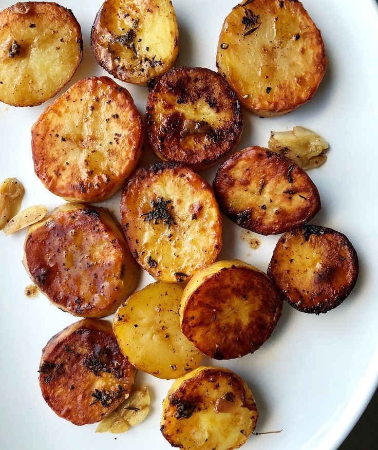 cooked potatoes on a white plate with seasoning