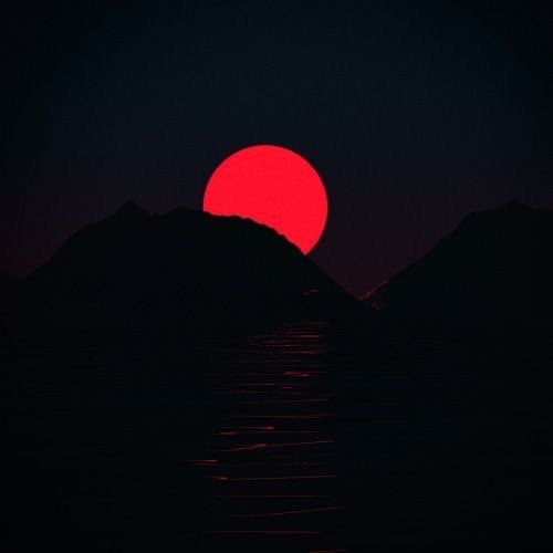 the sun is setting over some mountains in the dark night sky, with water below it