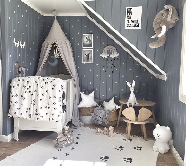 a child's bedroom with grey walls and white bedding, stuffed animals on the floor