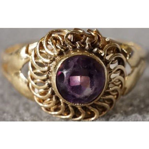 I am offering you this fabulous vintage 14 k yellow gold (stamped) with a round shaped, genuine intense amethyst stone, in a bold ring. This ring features a gorgeous shaped design with spectacular scrolled ridged etching. To enhance this marvelous setting the maker added these fabulous solid thick lines that wrap around this very substantial setting, it also has a very sleek look to it as well. Wow, what fabulous setting this is so very sleek, bold, and solid, check out the perfect color striati Victorian Style Purple Rings In 14k Gold, Victorian Style Purple Ring In 14k Gold, Victorian 14k Gold Ring In Purple, Victorian Style 14k Gold Rings In Purple, Victorian 14k Gold Purple Rings, Heirloom Gold Amethyst Ring With Center Stone, Gold Heirloom Amethyst Birthstone Ring, Heirloom Gold Birthstone Ring With Amethyst, Heirloom Amethyst Birthstone Ring In Gold