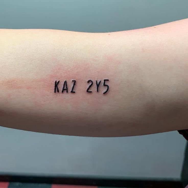 a person with a tattoo on their arm that says kal 2y5