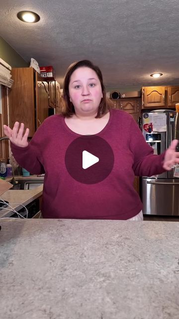 a woman standing in front of a kitchen counter with an appliance on it