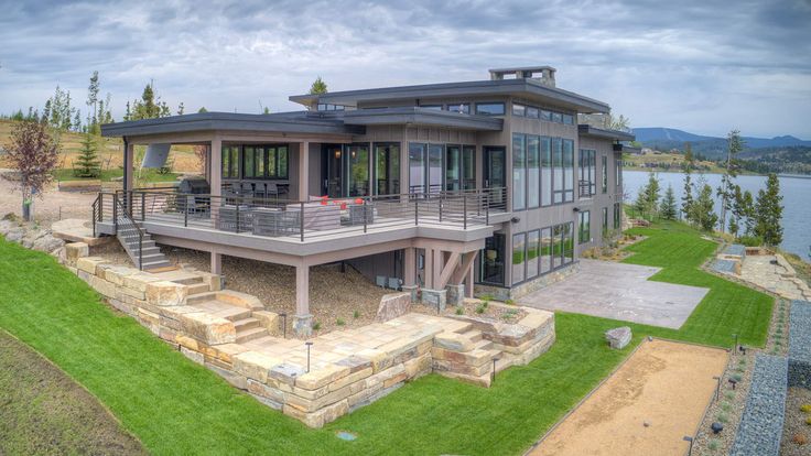 this is an aerial view of a modern house on the water's edge with stairs leading up to it