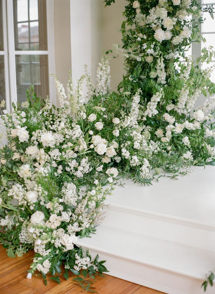 white flowers and greenery are on the steps