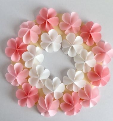 pink and white paper flowers arranged in a circle