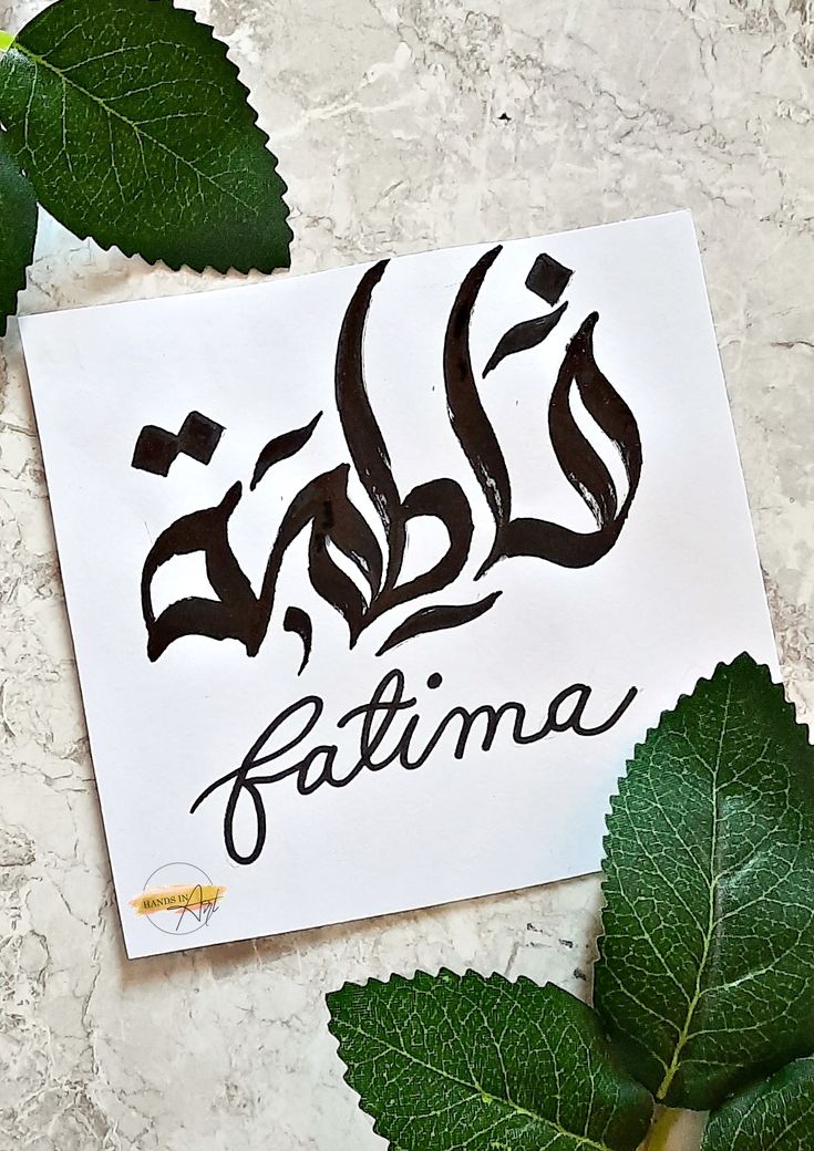 a piece of paper with the word fatima written on it next to some leaves