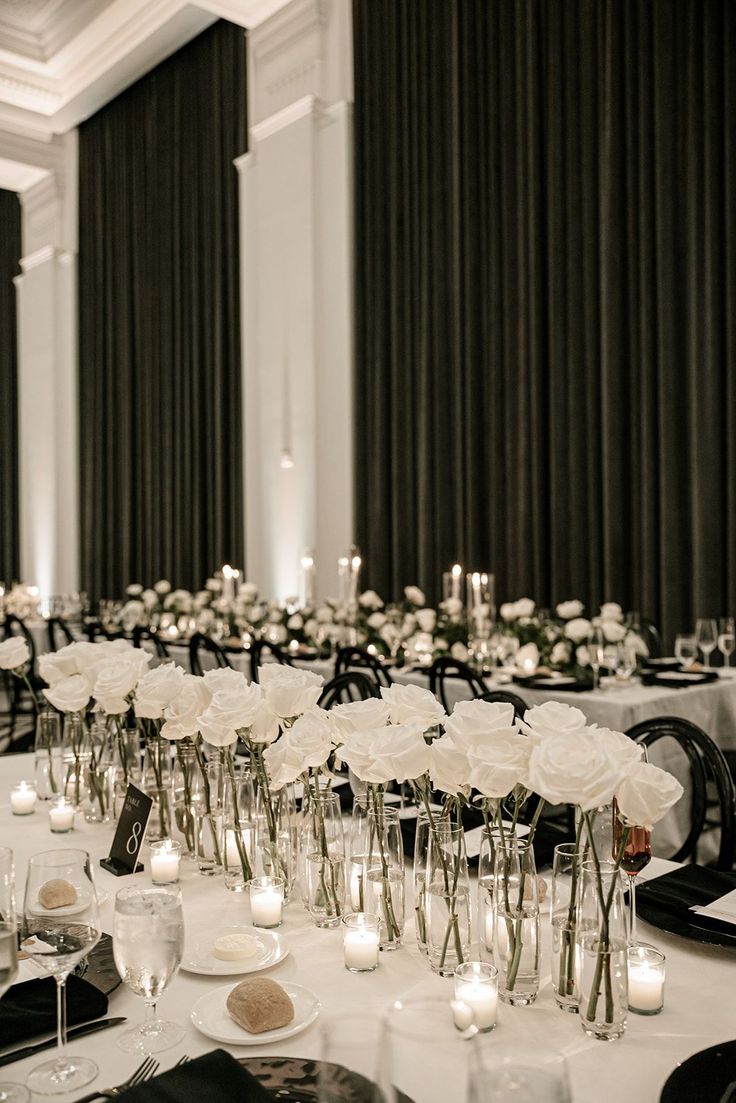 the tables are set with white flowers and candles