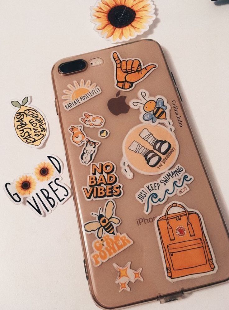 an iphone case with various stickers on it and a sunflower next to it