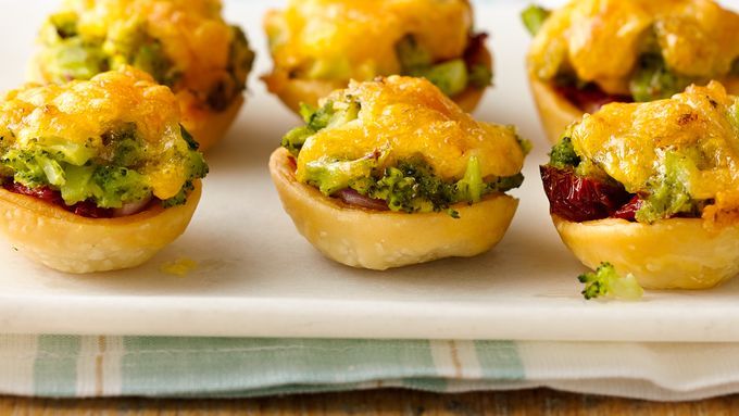 small appetizers with broccoli, cheese and other toppings on a plate