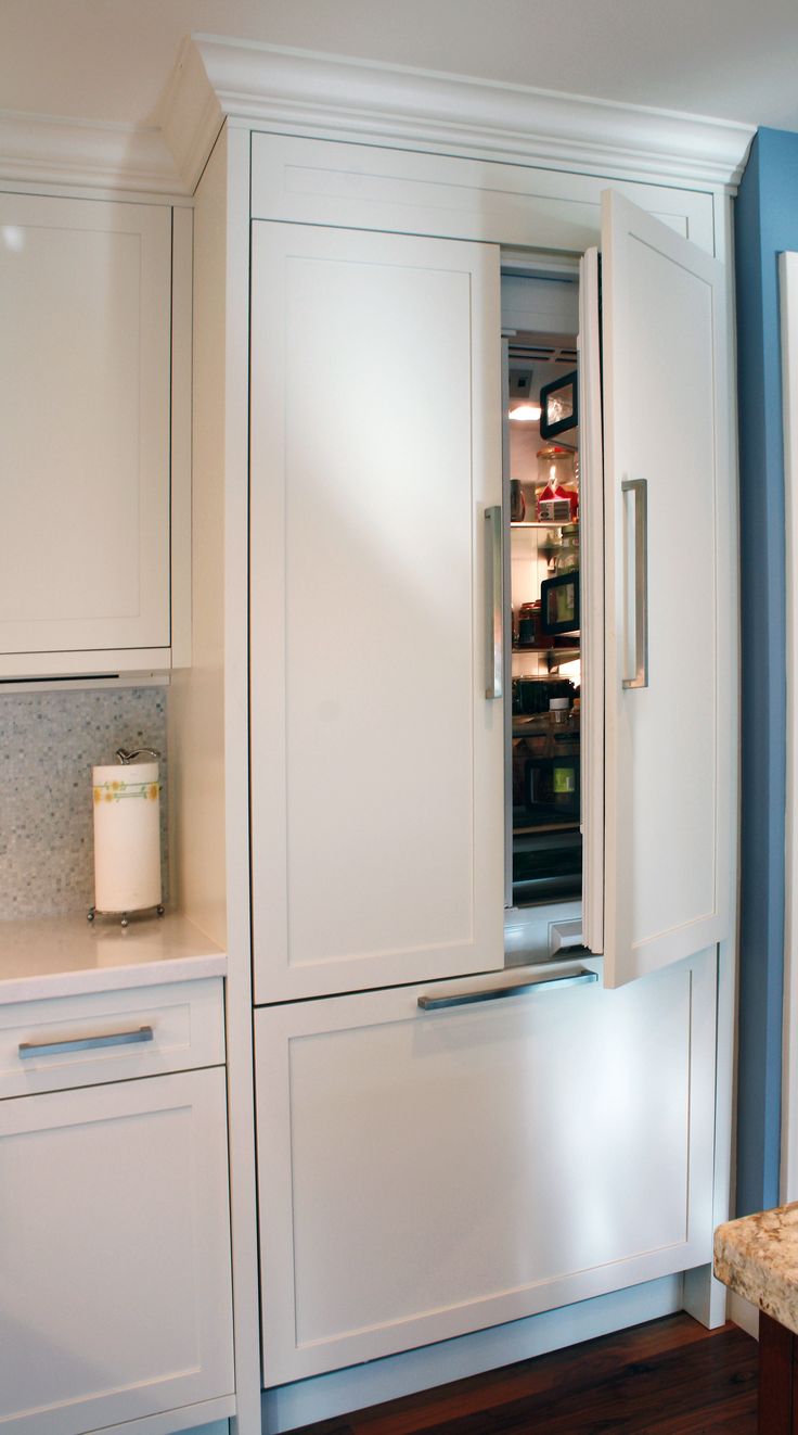 a refrigerator with its door open in a kitchen next to a counter top oven and cabinets