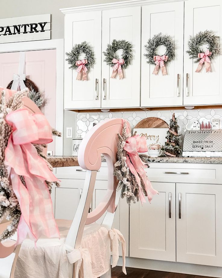 a pink chair in the kitchen decorated for christmas