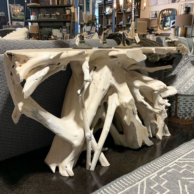 a table made out of driftwood is on display in a store with other furniture