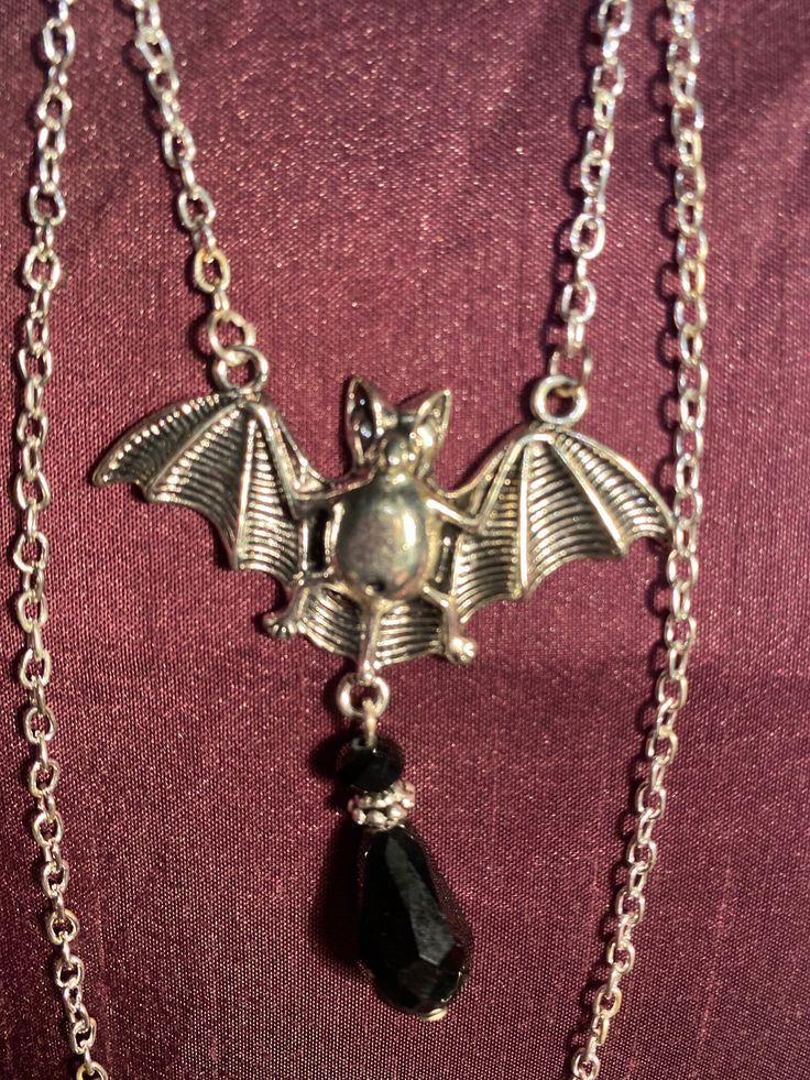 Bat and black gem necklace silver effect Silver Vampire Style Necklace, Gothic Dangle Necklaces For Parties, Gothic Pendant Necklace For Party, Nickel-free Halloween Party Necklace, Black Vampire Necklace For Party, Silver Vampire Style Metal Jewelry, Black Vampire Style Necklaces For Party, Black Vampire Style Necklace For Party, Gothic Metal Dangle Necklaces