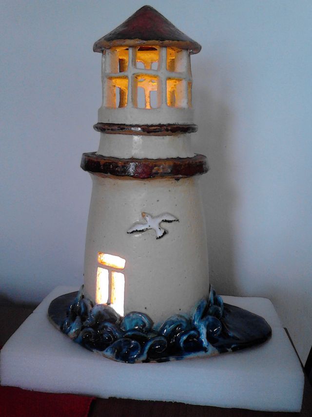 a white lighthouse with a light on top of it