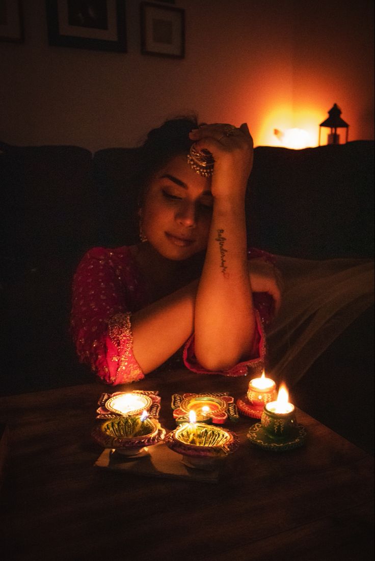 a woman sitting on a couch with candles in front of her