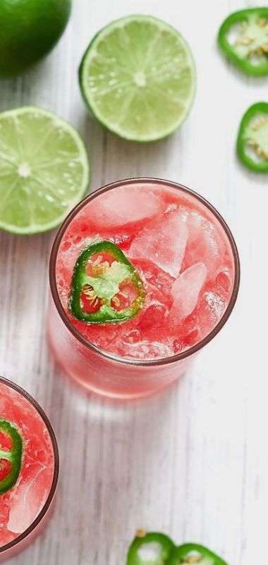 two glasses filled with watermelon and limeade on top of a white table