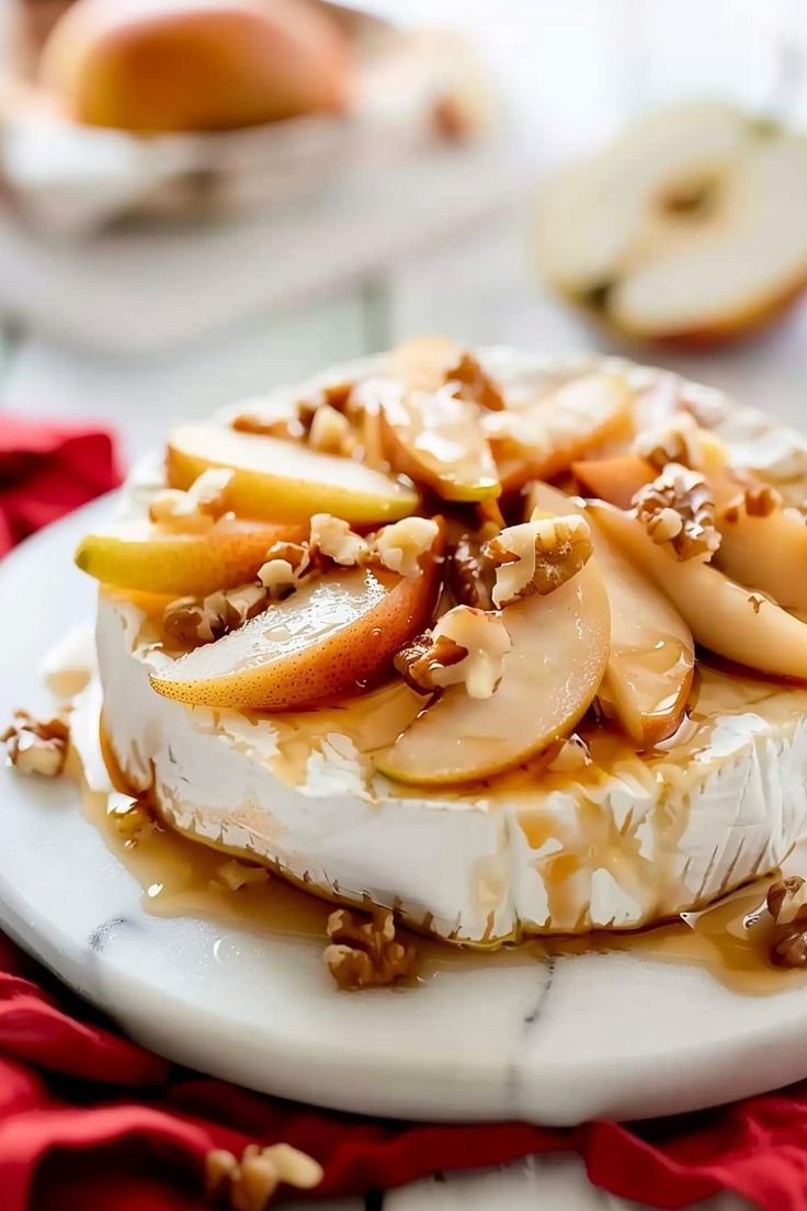 a piece of cheese with apples and walnuts on it sitting on a white plate