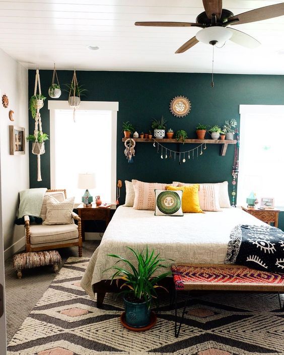 Picture Of a boho bedroom with a dark green accent wall, a bed, a woven ...