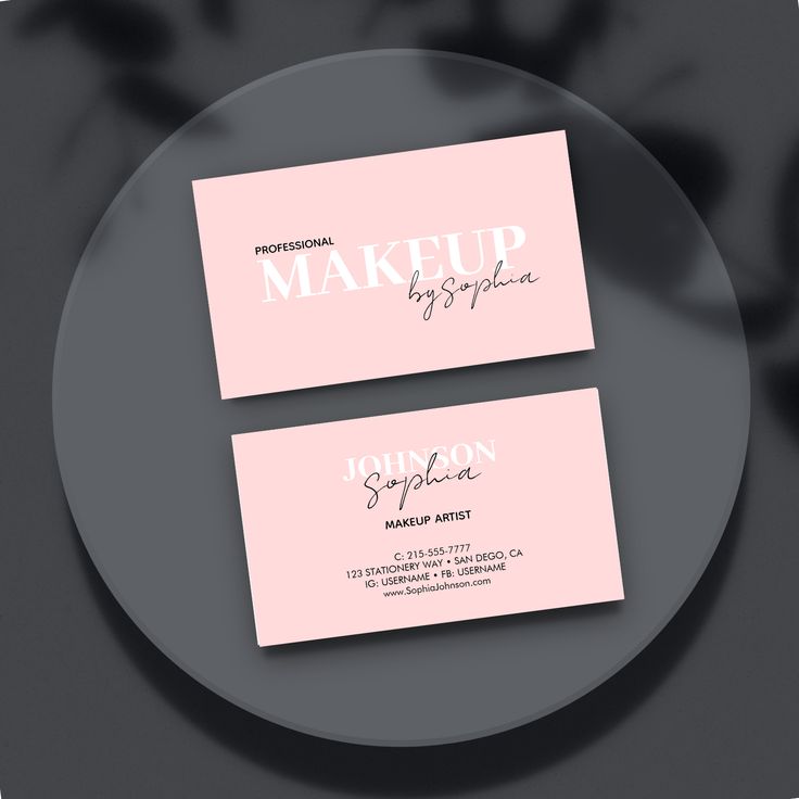 two pink business cards sitting on top of a plate