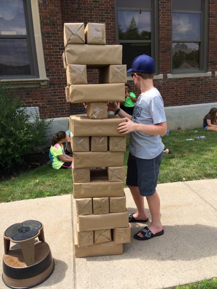 a young boy is playing with cardboard blocks