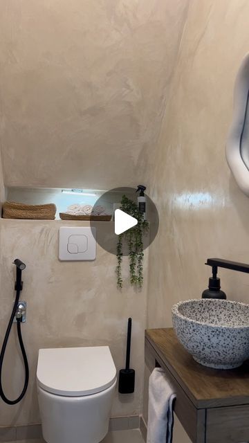 a white toilet sitting next to a sink in a bathroom under a mirror and faucet