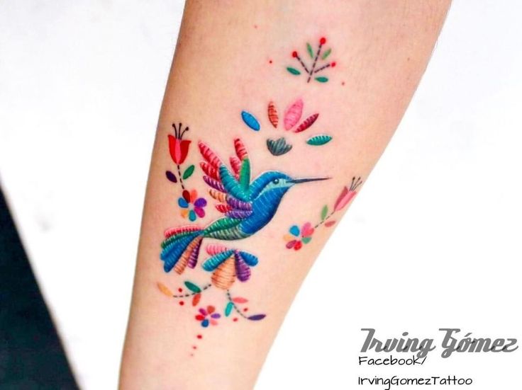 a colorful humming bird tattoo on the left arm