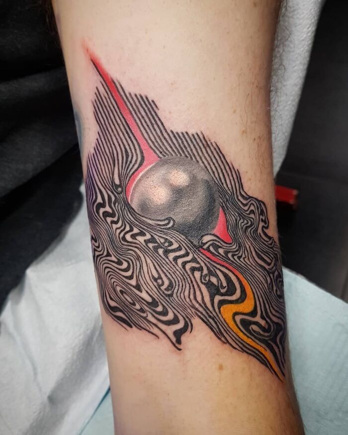 a tattoo on the arm of a person with a black and red design on it