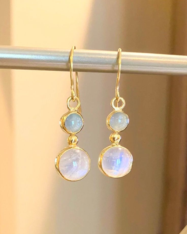 "Moonstone (10mm) and Aquamarine (6.5) set in 22 karat gold.  Stunning pair of drop earrings with the soft color of light blue aquamarine and the billowy moon-like sheen of the moonstone cradled in 22 karat yellow gold. The earring dangle 1.5\" from the earlobe." Elegant Moonstone Drop Earrings, Formal Round Moonstone Earrings, Moonstone Round Yellow Gold Earrings, Moonstone Yellow Gold Round Earrings, Blue Moonstone Round Earrings, Yellow Gold Moonstone Dangle Earrings, Round Moonstone Yellow Gold Earrings, Round Moonstone Cabochon Earrings, Yellow Gold Round Moonstone Earrings