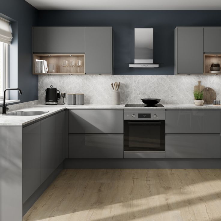 a modern kitchen with gray cabinets and white counter tops, wood flooring and wooden floors