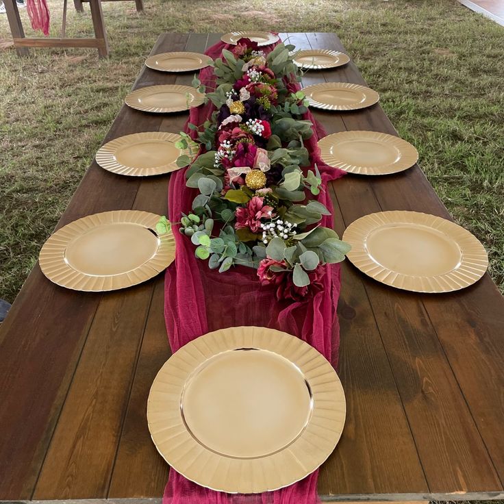 a long table with plates and flowers on it